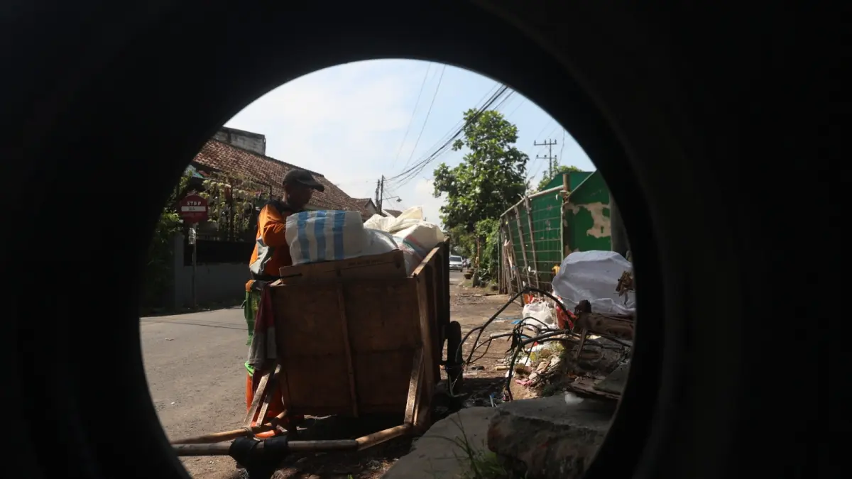 BAKAL LEBIH MODERN: Seorang petugas pengangkut sampah di TPS Mergan Kota Malang memilah sampah yang ada di gerobaknya. Kota Malang menjadi salah satu dari 10 wilayah prioritas pembangunan LSDP. (foto: Darmono/Radar Malang)