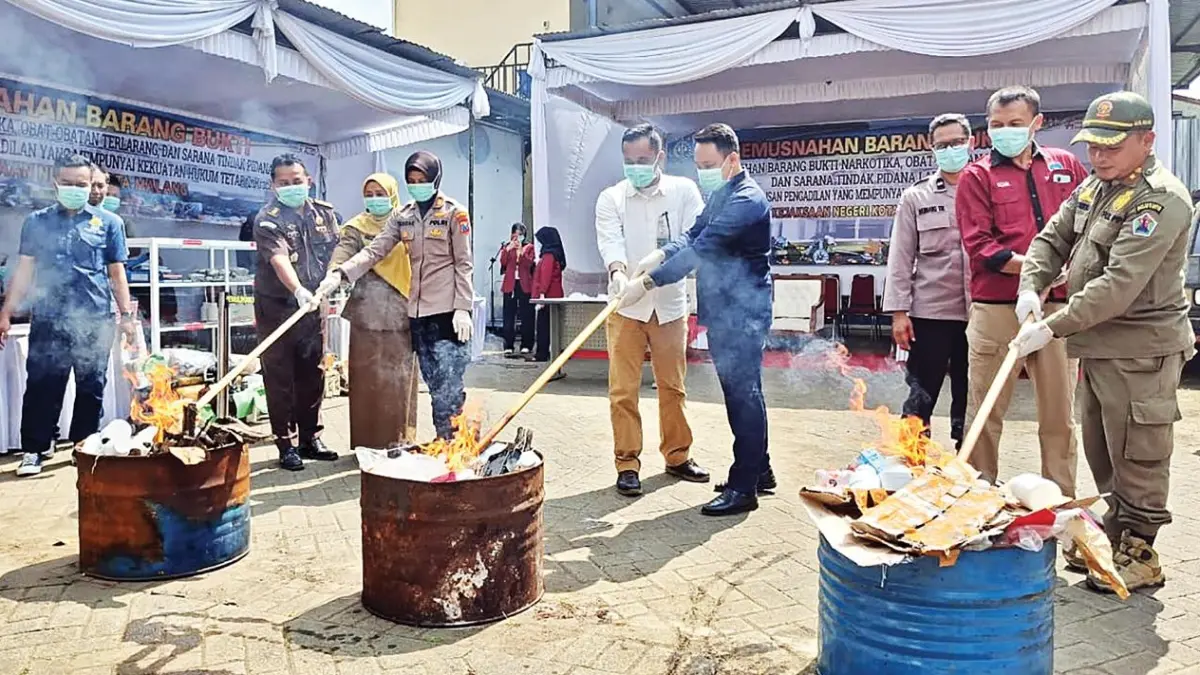 BERAGAM: Pemusnahan sejumlah barang bukti tindak kriminal dilakukan di halaman Kejari Kota Malang, kemarin (12/5). Sejumlah pihak turut hadir menyaksikan. (Nabila Amelia/Radar Malang)