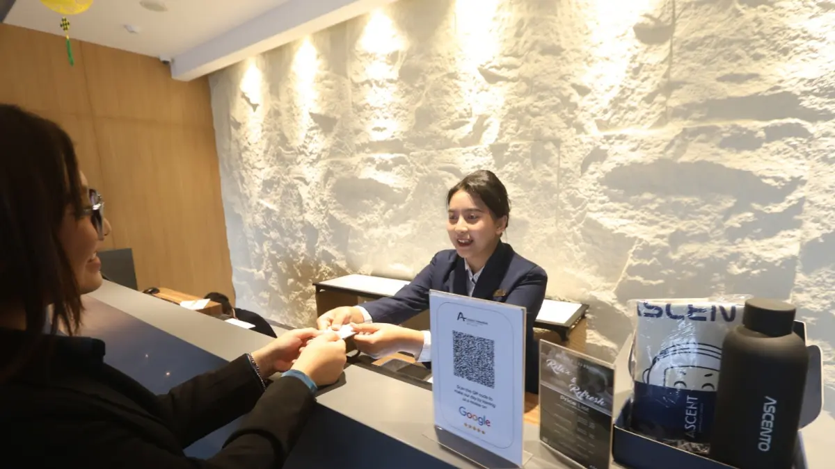 PERKEMBANGAN POSITIF: Resepsionis Ascent Premiere Hotel and Convention (kanan) memberi kunci kamar kepada salah satu pengunjung hotel, beberapa waktu lalu. (foto: Darmono)