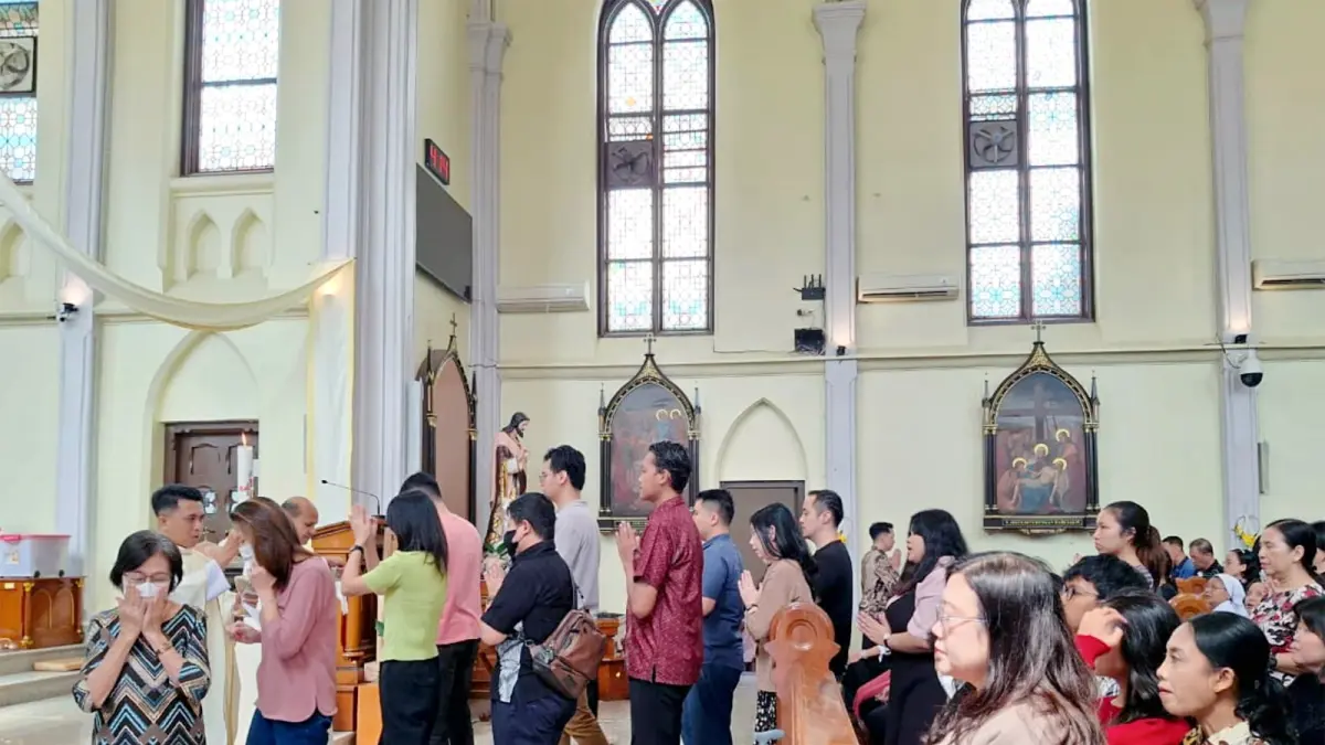 ANIMO TINGGI: Umat Katolik menerima komuni secara bergantian dalam Perayaan Ekaristi Kenaikan Yesus Kristus di Gereja Hati Kudus Yesus Kayutangan, kemarin (14/5). (Nabila Amelia/Radar Malang)