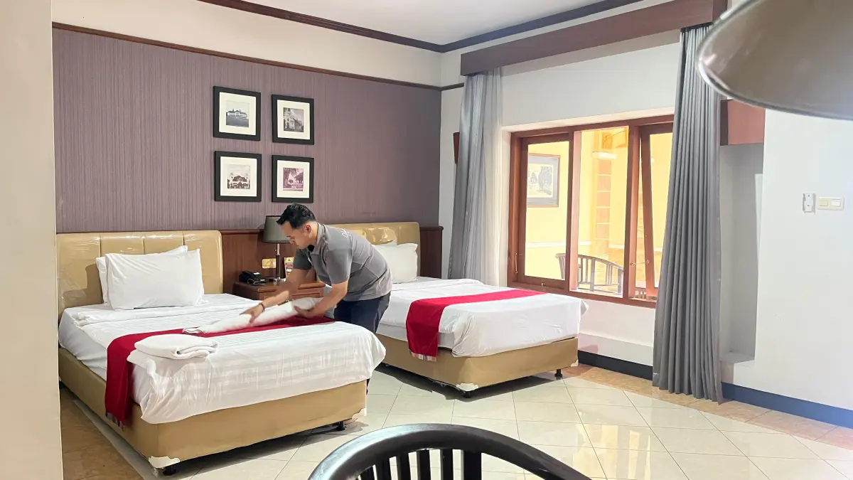 DIRAPIKAN: Petugas Pelangi Hotel membersihkan kamar yang akan ditempati tamu hotel. Okupansi harian Hotel di Kota Malang capai 40-50 persen saat ini. (foto: Nahdiatul Affandiah/Radar Malang)
