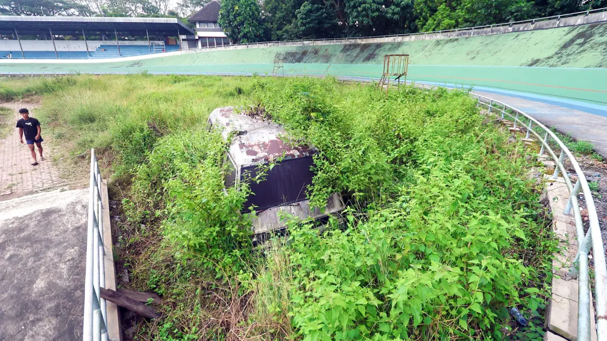 BELUM ADA JALAN KELUAR: Bagian dalam Velodrome tetap tak terawat sampai saat ini. Rumput tumbuh liar. Beberapa sisi bangunan juga mulai lapuk. (Darmono/Radar Malang)