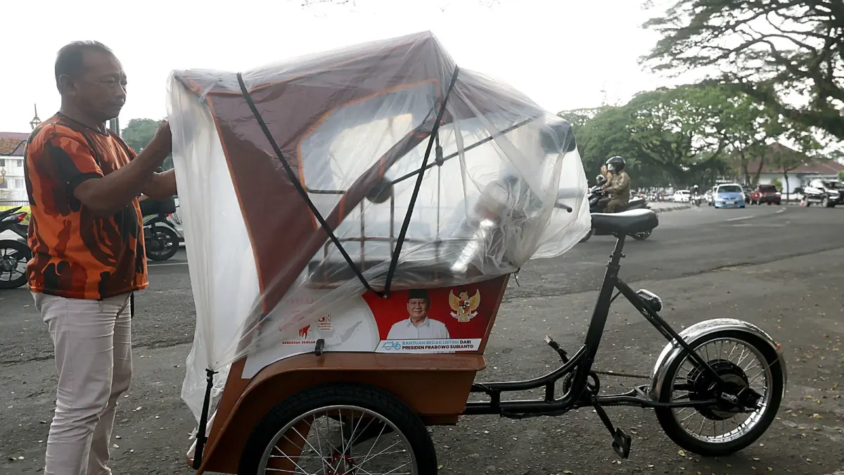 TUNGGU REGULASI: Salah satu pengayuh becak listrik ngetem di Alun-Alun Tugu, kemarin (15/5). (Darmono/Radar Malang)
