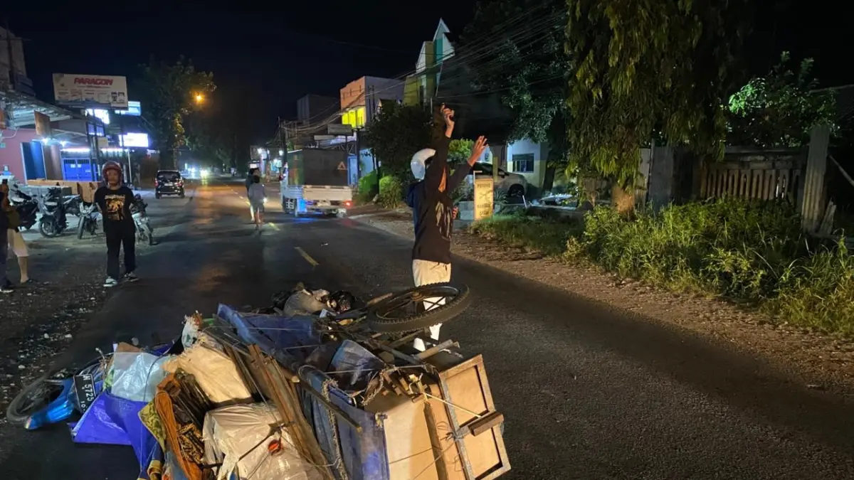 Kondisi motor dan gerobak yang tergeletak setelah terserempet truk tangki BBM di Jalan Raya Sumberpucung, Minggu (17/5) dini hari. (Dharaka Pradana for Radar Malang)