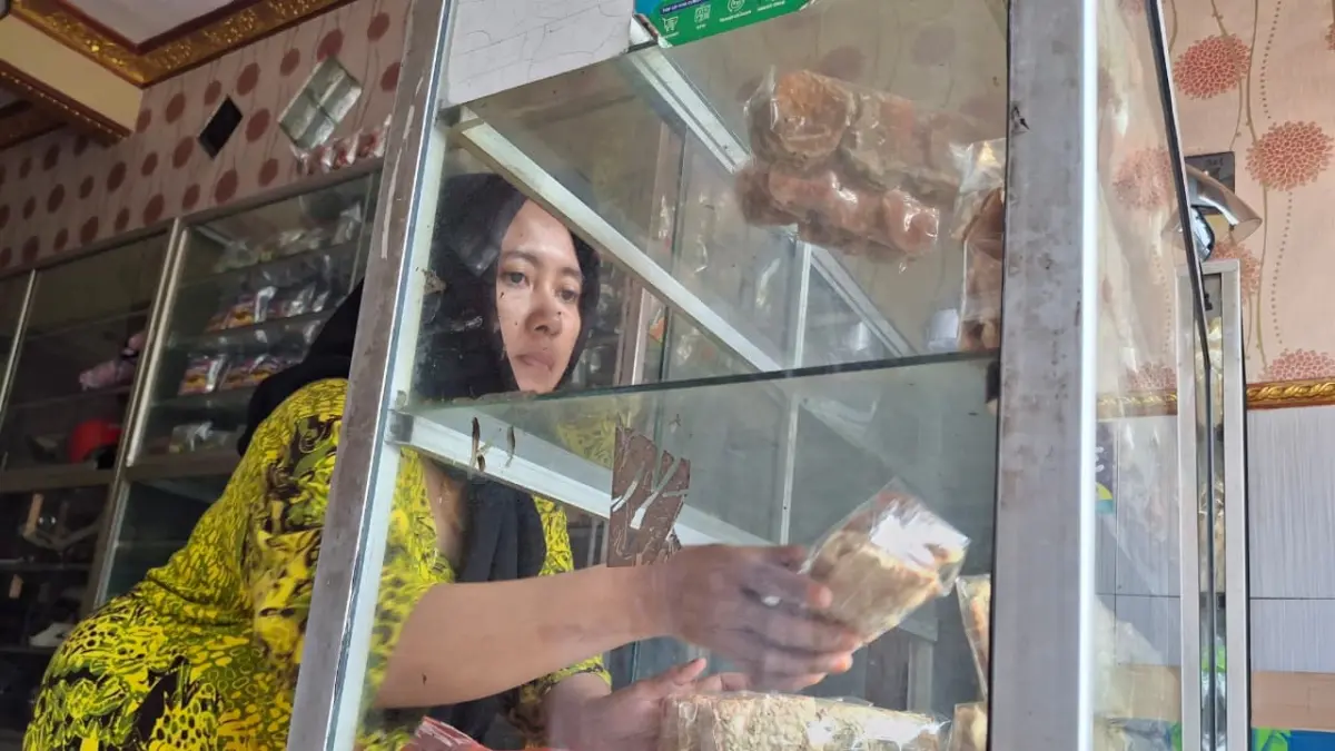 TERIMBAS DOLAR: Salah satu penjual keripik tempe mengeluhkan kenaikan beberapa harga bahan. Selain kedelai, juga ada kenaikan bahan plastik. (Nabila Amelia/Radar Malang)