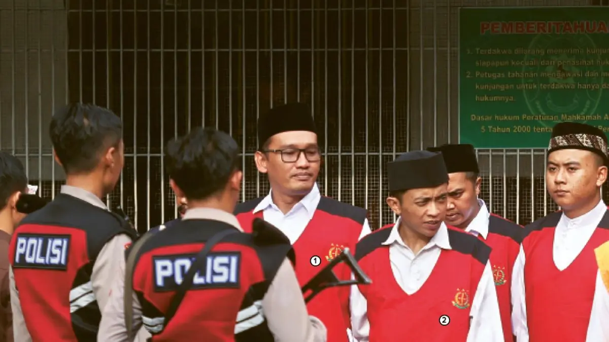 KELUARGA KORBAN DILARANG MASUK: 1) Bripka Agus Muhamad Saleman dan 2) Suyitno, dua terdakwa kasus pembunuhan terhadap mahasiswi UMM setelah menjalani sidang perdana di PN Malang, kemarin (20/5). (Darmono/Radar Malang)