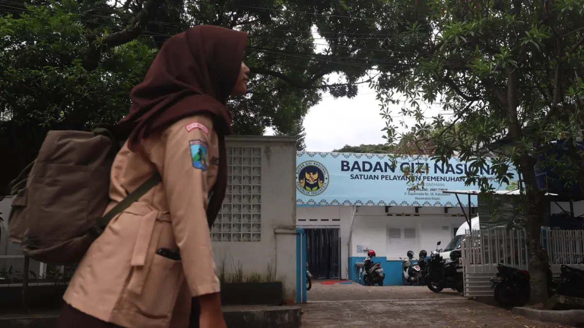 WAJIB SESUAI SOP: Seorang siswa melintas di depan salah satu SPPG yang ada di Kota Malang beberapa waktu lalu. (foto: Darmono)

&nbsp;