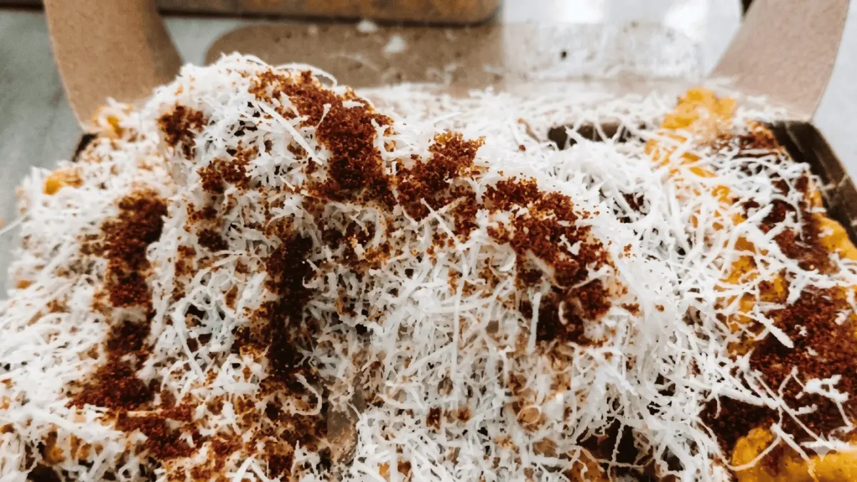 Pisang goreng dengan taburan keju parut dan bubuk cokelat yang melimpah. (Zendy Brand / Google Maps)