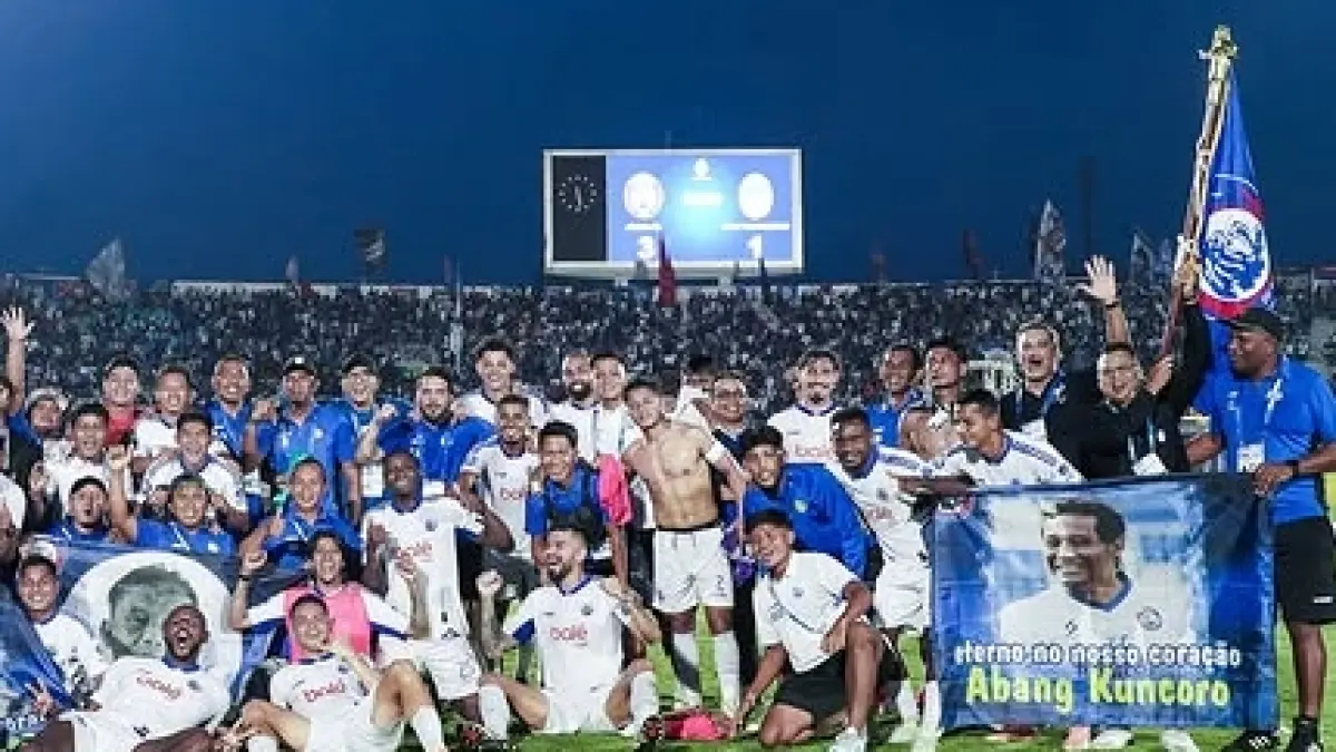 PENGHORMATAN: Pemain dan staf Arema FC saat mengibarkan bendera bergambar sosok almarhum Kuncoro, Jumat lalu (22/5).