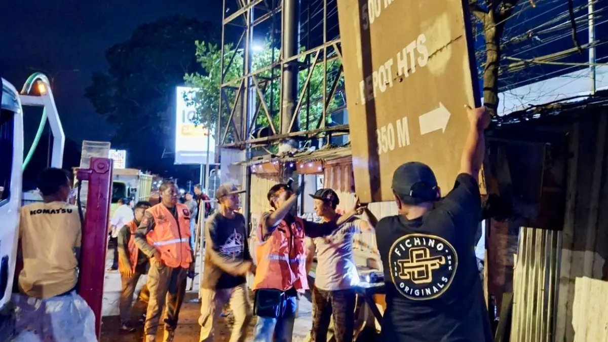 Personel Satpol PP Kabupaten Malang membongkar reklame bermasalah di Jalan Dr Cipto, Bedali, Lawang, Jumat (22/5) malam. (Satpol PP Kabupaten Malang)
