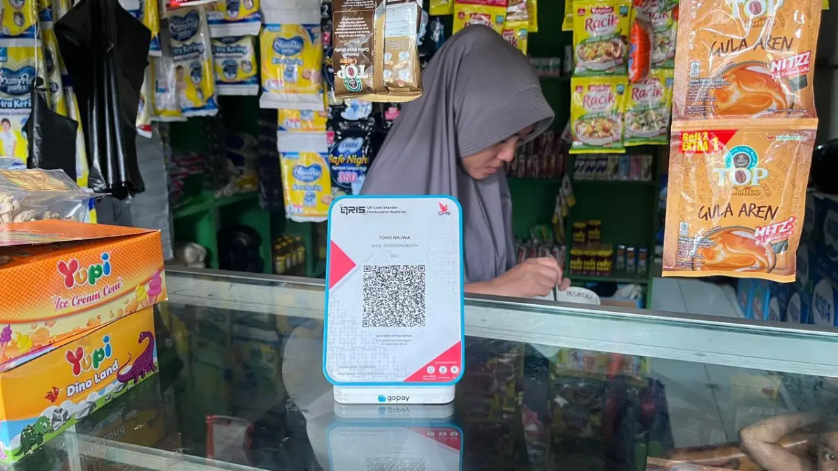 Seorang pedagang menggunakan QRIS. (Nahdiatul Affandiah/Radar Malang)