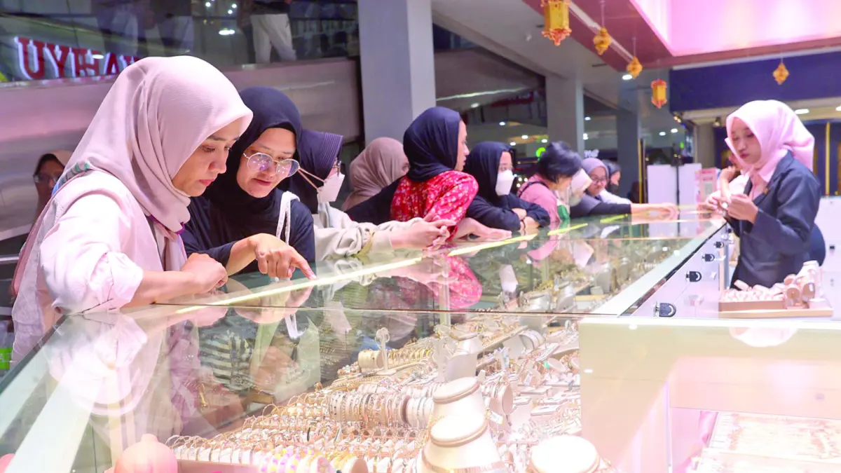 MANFAATKAN MOMENTUM: Seorang pembeli tengah mencari emas di salah satu toko perhiasan yang ada di Kota Malang, beberapa waktu lalu. (Foto: Darmono/Radar Malang)
