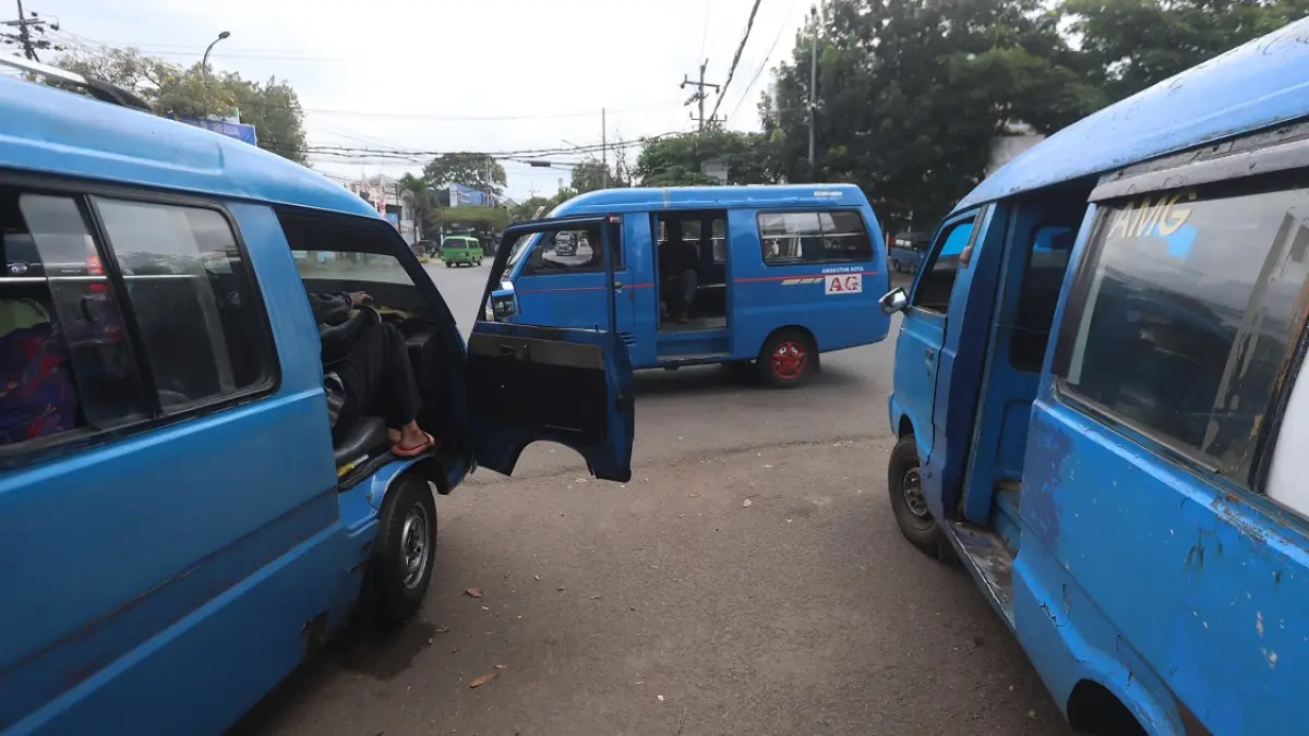 TUNGGU ACC PEMPROV: Sejumlah angkot ngetem di Jalan Kolonel Sugiono, Sukun, kemarin. Belum ada tanda-tanda dimulainya program angkutan pelajar gratis. (Darmono/Radar Malang)