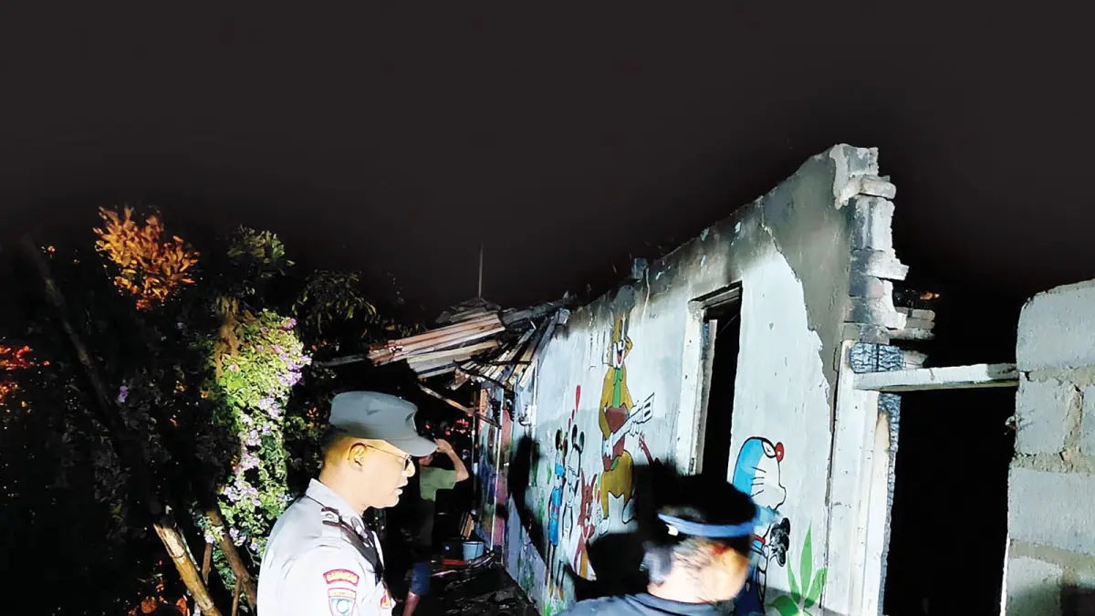 Aparat kepolisian bersama tim Damkar Kabupaten Malang memeriksa rumah korban yang hangus terbakar.