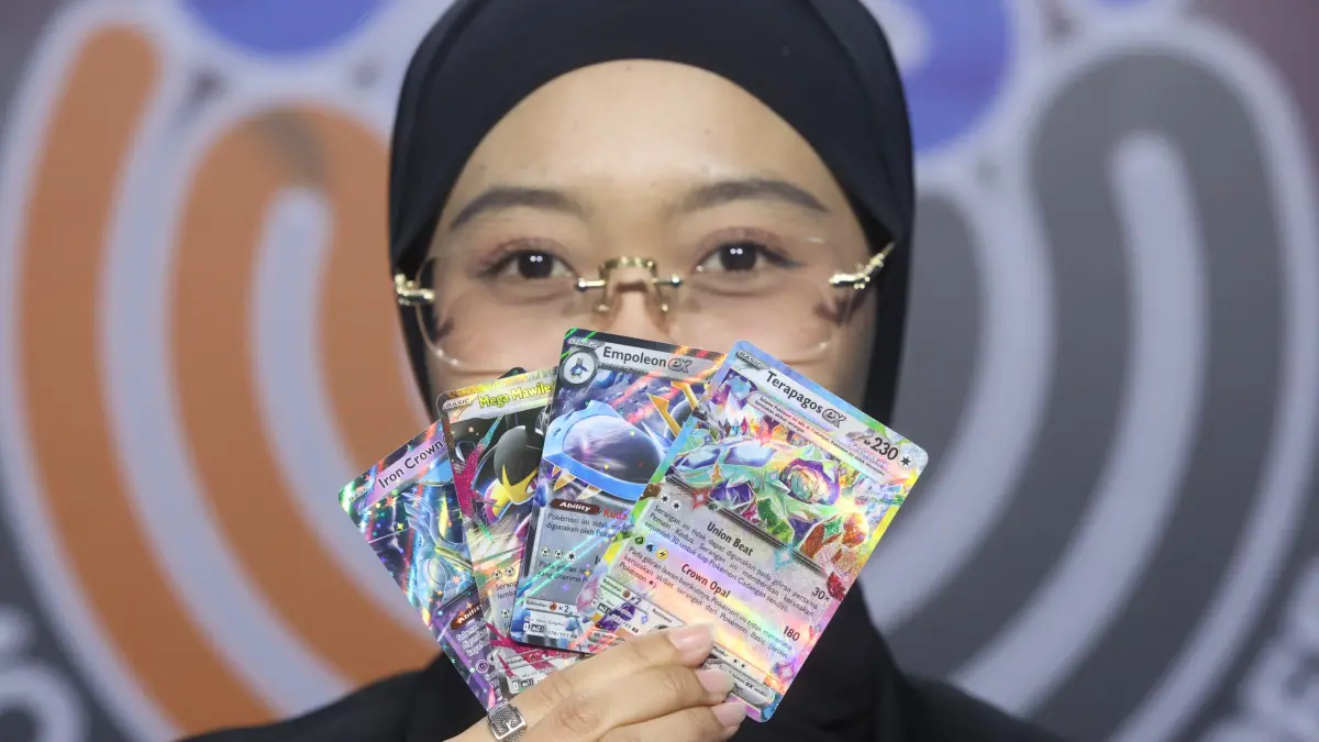TENGAH DIGEMARI: Seorang kolektor menunjukkan koleksi kartu Pokémon kemarin. Kartu Pokémon sedang ramai diburu untuk koleksi hingga investasi. (Darmono/Radar Malang)