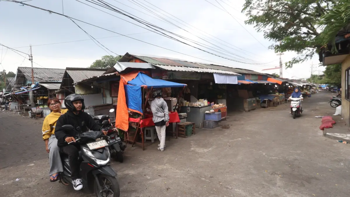 JADI SASARAN PERTAMA: Seorang pembeli meninggalkan Pasar Blimbing, kemarin. Program Warung Tekan Inflasi (WTI) akan hadir di Pasar Blimbing dan Pasar Dinoyo pekan ini. (Foto: Darmono/Radar Malang)