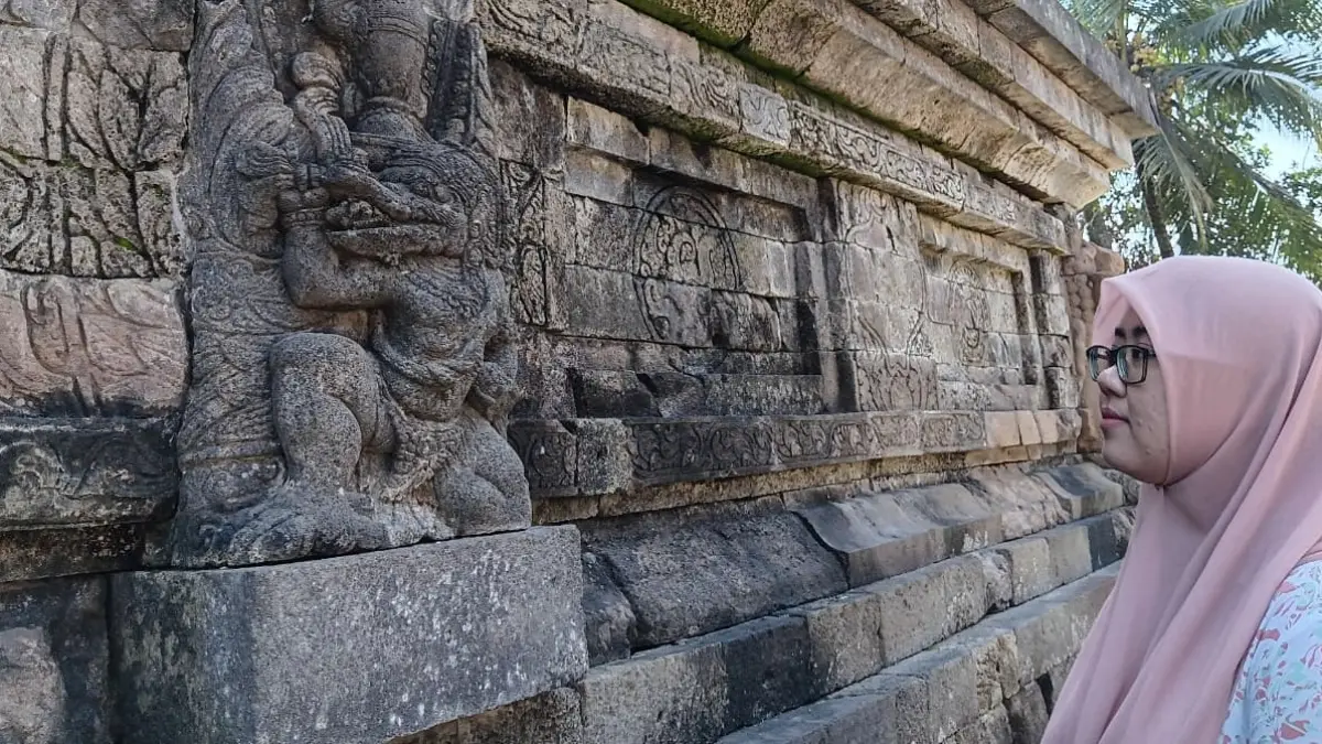 Wisatawan melihat relief garuda di Candi Kidal Tumpang Malang, Selasa (2/6). (Indah Mei Yunita/Radar Malang)