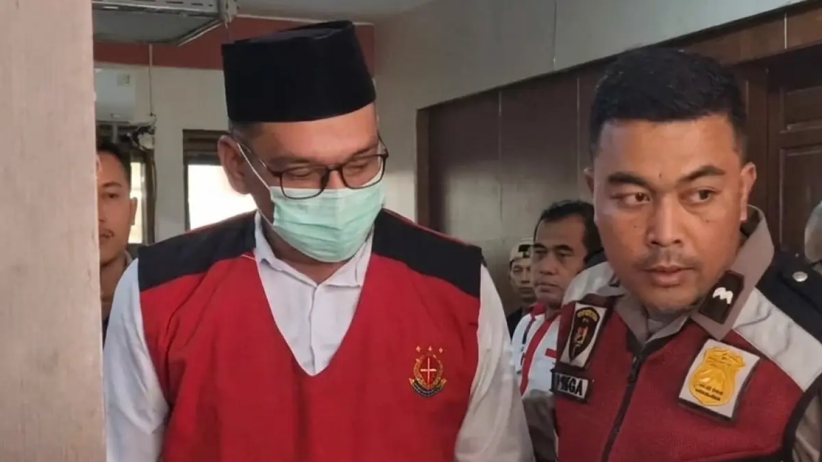 Bripka Agus Muhamad Saleman (kiri) digiring menuju ruang sidang PN Malang, Rabu (3/6). (Nabila Amelia/Radar Malang)