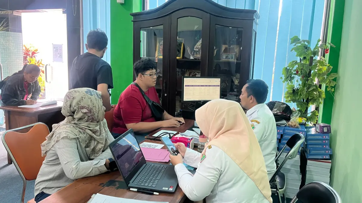 FOKUS: Wali murid calon pendaftar sedang melakukan input nilai rapor di Posko SPMB Disdikbud Kota Malang kemarin (3/6). (Foto: Nahdiatul Affandiah/Radar Malang)