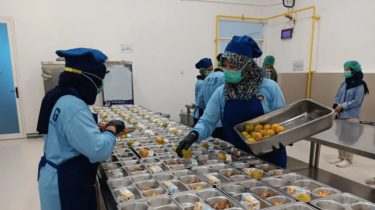 SESUAI PORSI: Relawan SPPG Karangploso menata buah jeruk di food tray pekan lalu. Sebanyak 11.891 relawan SPPG bakal terdaftar BPJS Kesehatan. (Indah Mei Yunita/Radar Malang)