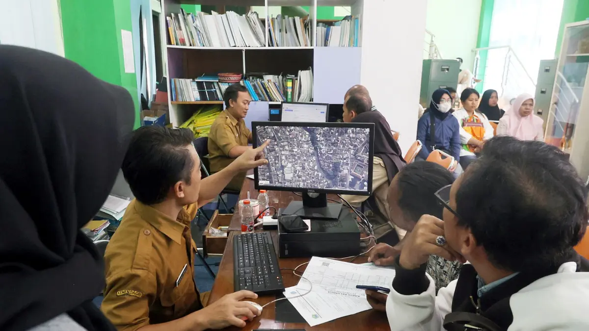 BANYAK DIKELUHKAN: Salah satu operator di Posko SPMB Disdikbud Kota Malang menjelaskan titik domisili kepada salah satu wali murid, kemarin. (Darmono/Radar Malang)