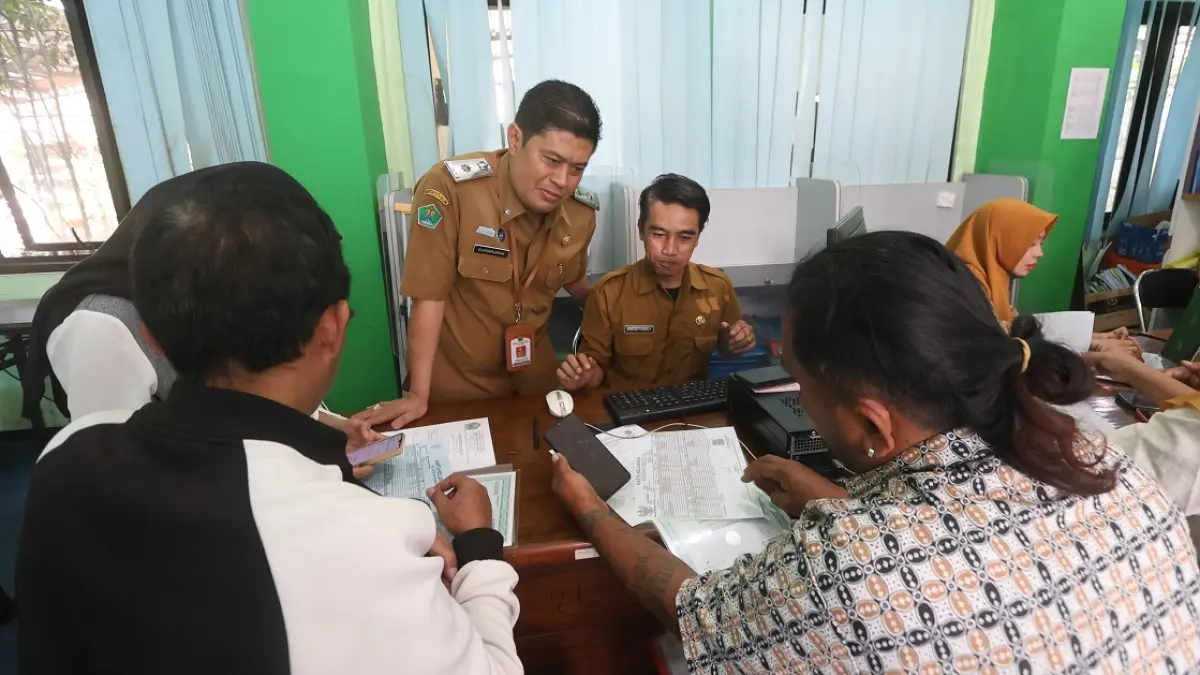 TERAPKAN ATURAN BARU: Kepala Disdikbud Kota Malang Suwarjana ikut memantau pelayanan di Posko SPMB, kemarin. (Darmono/Radar Malang)