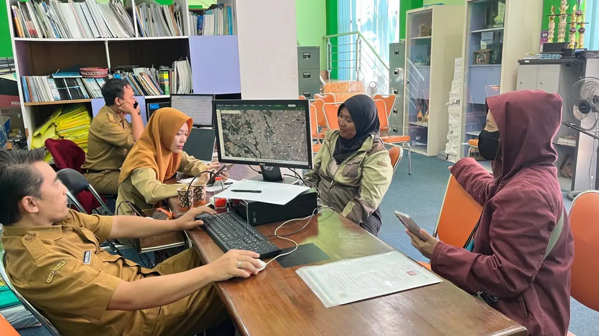 HARI KEDUA: Salah satu wali murid calon pendaftar berkonsultasi ke Posko SPMB di Kantor Disdikbud Kota Malang, kemarin (9/6). (Nahdiatul Affandiah/Radar Malang)