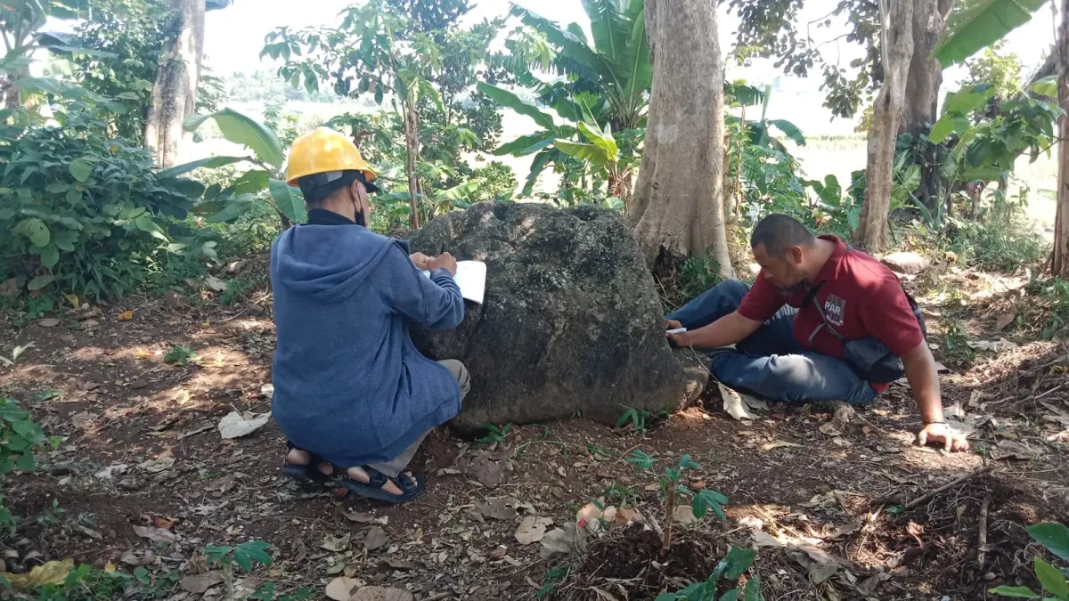 BERSEJARAH: Petugas memeriksa temuan batu di Desa Watugede, Kecamatan Singosari kemarin (10/6).