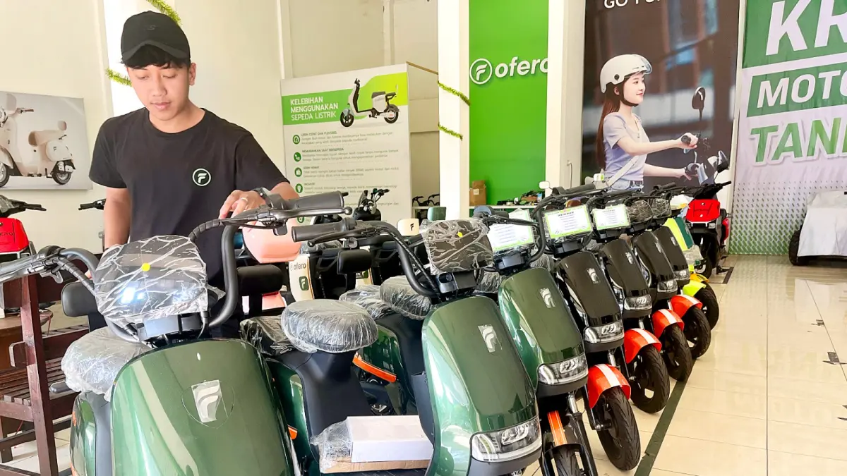 LARIS: Petugas di diler motor listrik di Jalan Agung Suprapto merapikan display kendaraan, kemarin (13/6). Sejak awal bulan ini, banyak pesanan motor listrik dari pelanggan. (NAHDIATUL AFFANDIAH/RADAR MALANG)