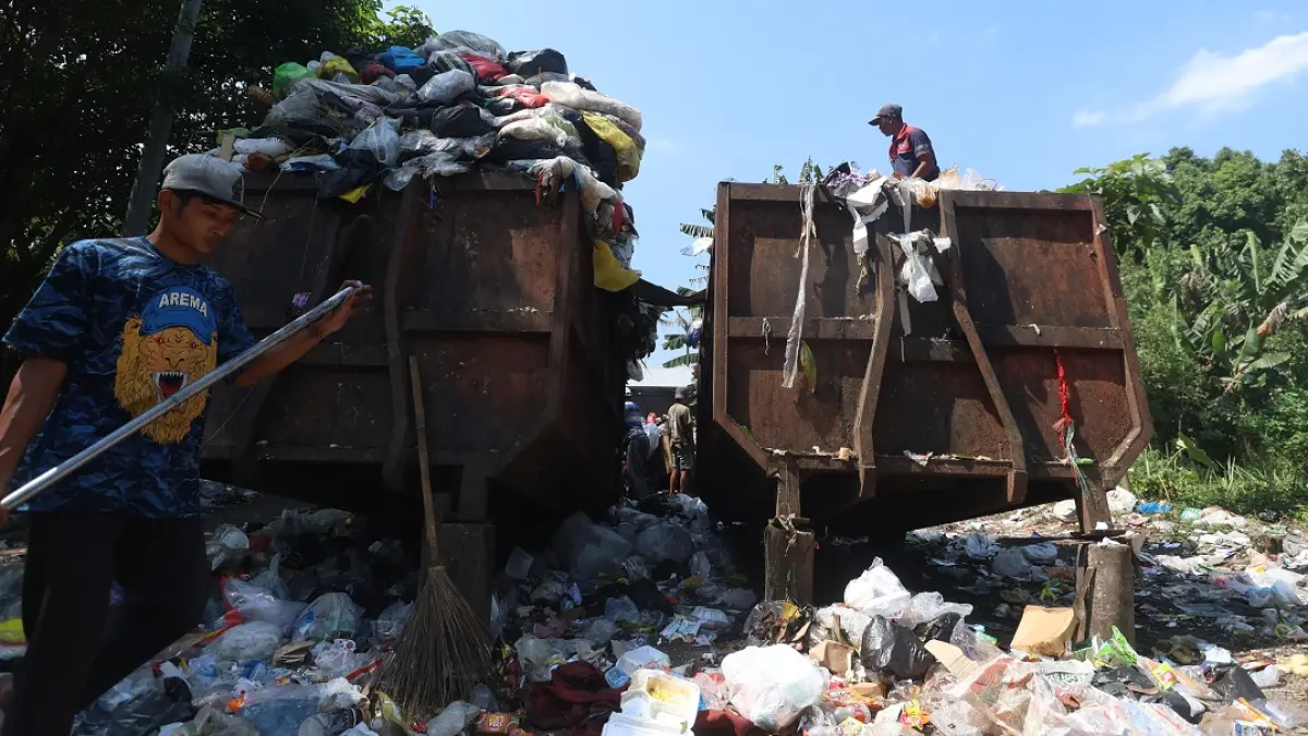 BUTUH PENAMBAHAN: Dua truk sampah beroperasi di TPS Buring, kemarin. Mayoritas armada truk sampah yang ada sudah berusia tua. (Darmono/Radar Malang)