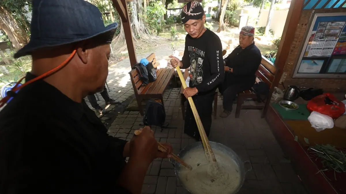 JADI 150 PORSI: Warga yang tinggal di sekitar Pesarean Ki Ageng Gribig, Kelurahan Madyopuro, Kecamatan Kedungkandang bersama-sama memasak bubur untuk dibagikan kepada pengunjung. (Darmono/Radar Malang)