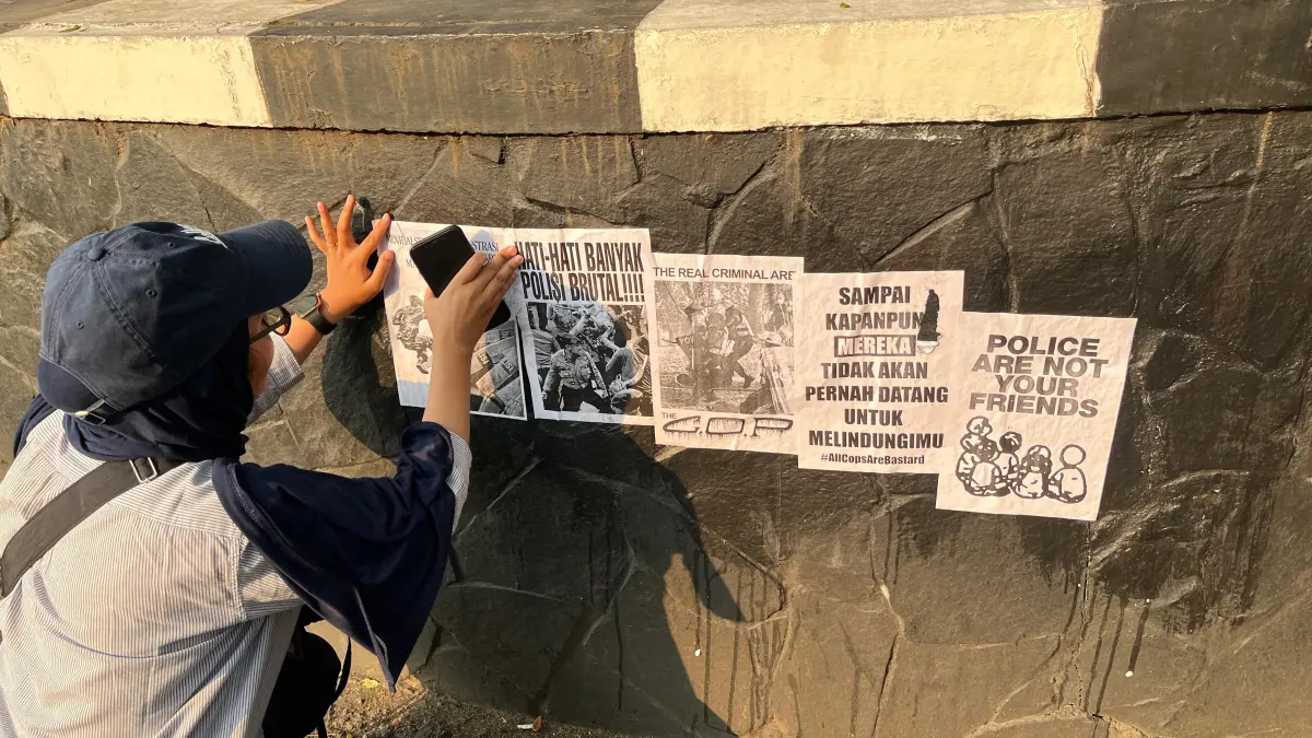 Mahasiswa yang tergabung dalam Aliansi Malang Bergerak memasang poster protes di depan gedung DPRD Kota Malang, Rabu (17/6). (Nahdiatul Affandiah/Radar Malang)