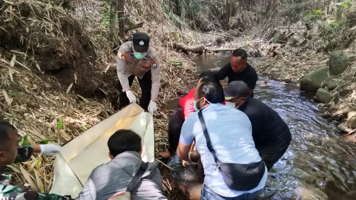 Personel Polsek Karangploso dibantu warga mengevakuasi lansia yang meninggal di Sungai Ngenep. (Polsek Karangploso)