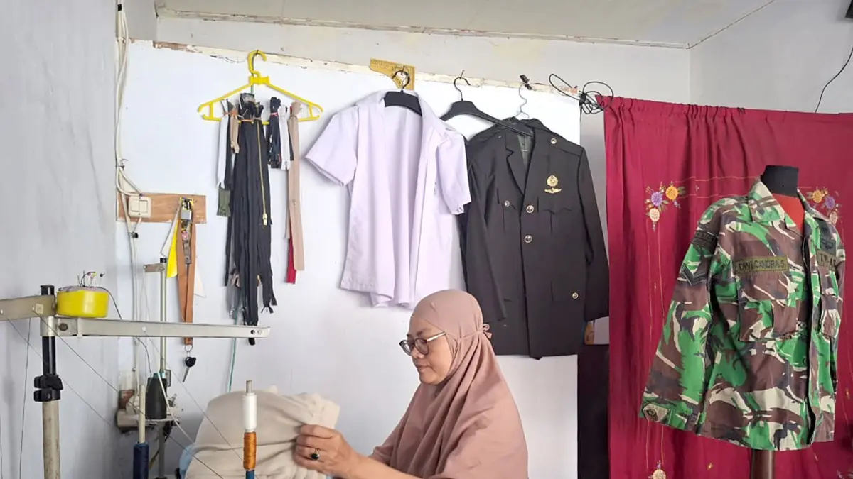 TERGANGGU: Pegawai di Assegaf Potong Rambut menggunakan alat cukur portable ketika terjadi pemadaman listrik, kemarin. (Assegaf Potong Rambut For Radar Malang)