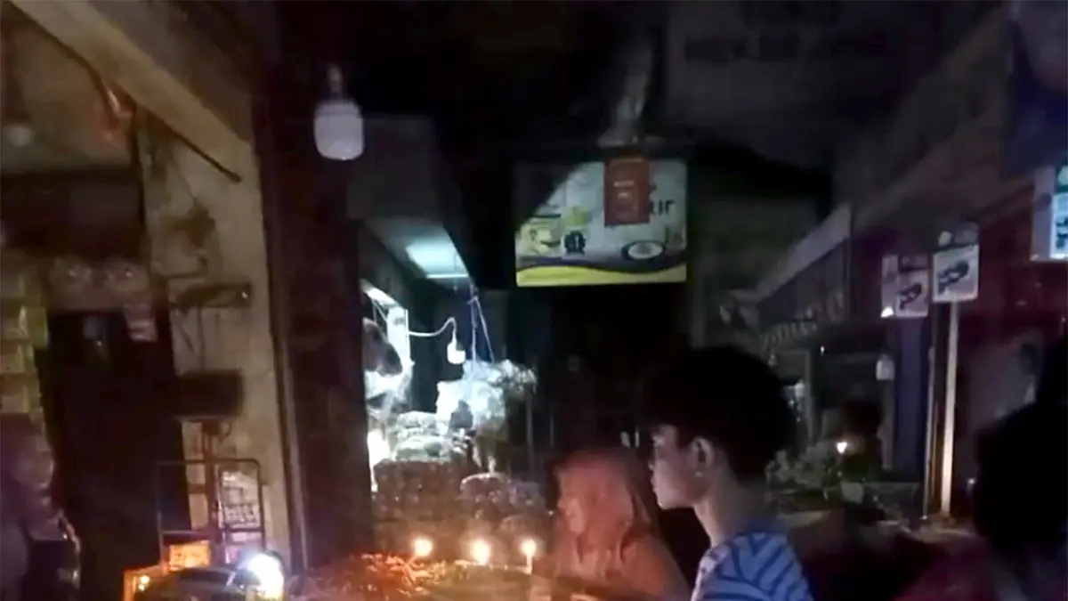 LEBIH DARI SEJAM: Penjual di salah satu stan penjual daging di Pasar Besar Malang mendokumentasikan padamnya listrik, kemarin. (Rosi Yanti For Radar Malang)