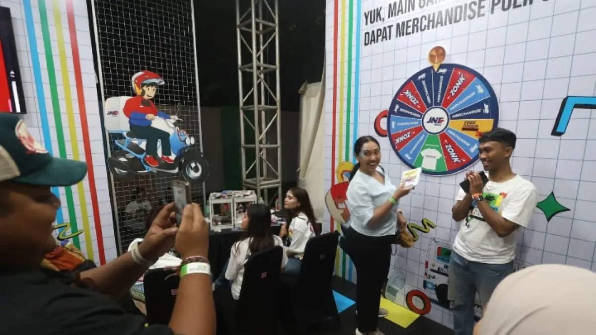 MERIAH: Penonton mengikuti permainan di booth JNE.
