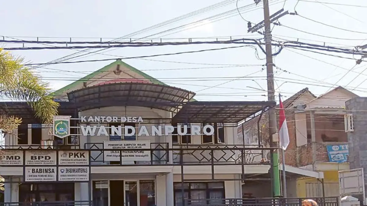 PILKADES: Seorang pengendara melintas di depan Kantor Desa Wandanpuro kemarin (20/6). Tahun ini Wandanpuro menggelar Pilkades Antar-Waktu.