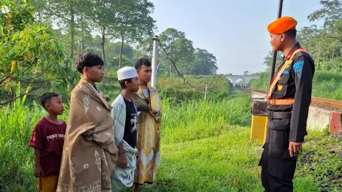 WASPADA: Petugas KAI mengingatkan sejumlah anak yang berada di dekat rel kereta.