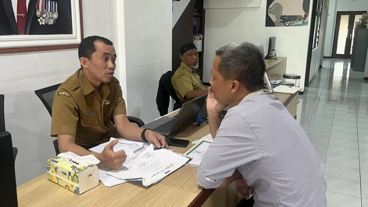 KONSULTASI: Salah satu pendaftar menanyakan ketentuan SPMB di Posko Cabdin Kota Malang-Kota Batu, Rabu lalu (24/6). (Nahdiatul Affandiah/Radar Malang)