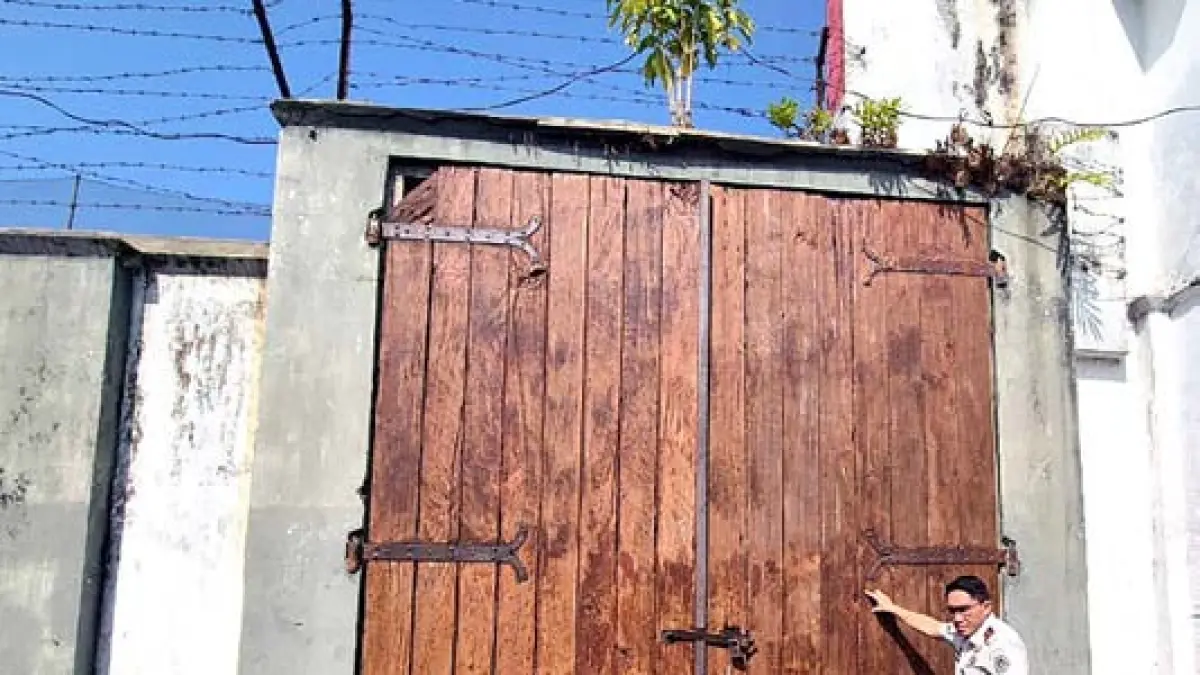 BERSEJARAH: Petugas Lapas Kelas 1 Malang menunjukkan gerbang kayu raksasa yang pernah dilintasi jalur kereta api masa Hindia Belanda.