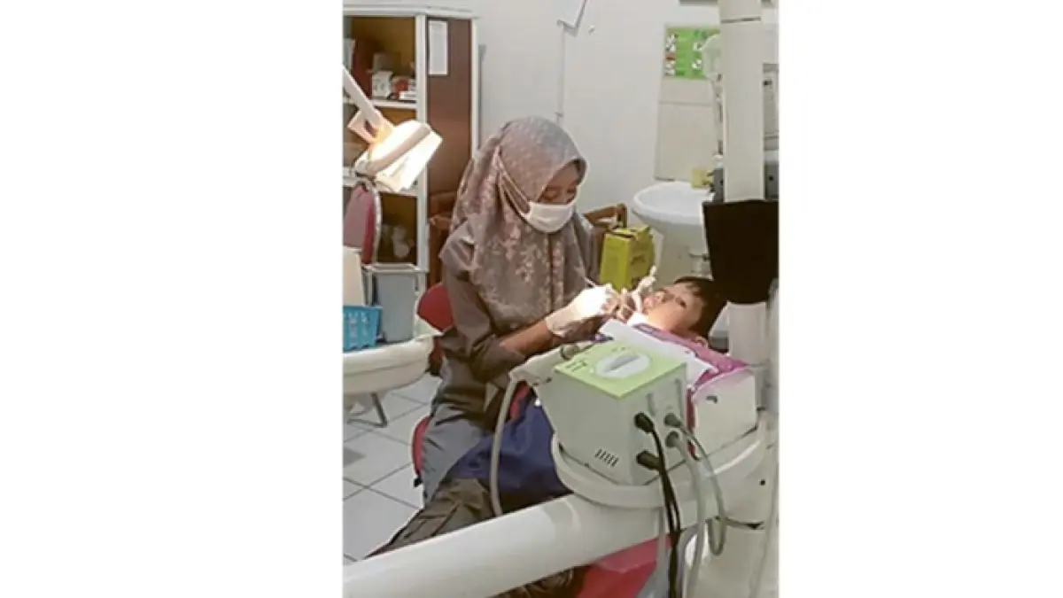 FOKUS: Kepala Klinik Muhammadiyah Blimbing dr Effah Afiyati tengah memeriksa pasien yang sedang melakukan perawatan gigi, beberapa waktu lalu.