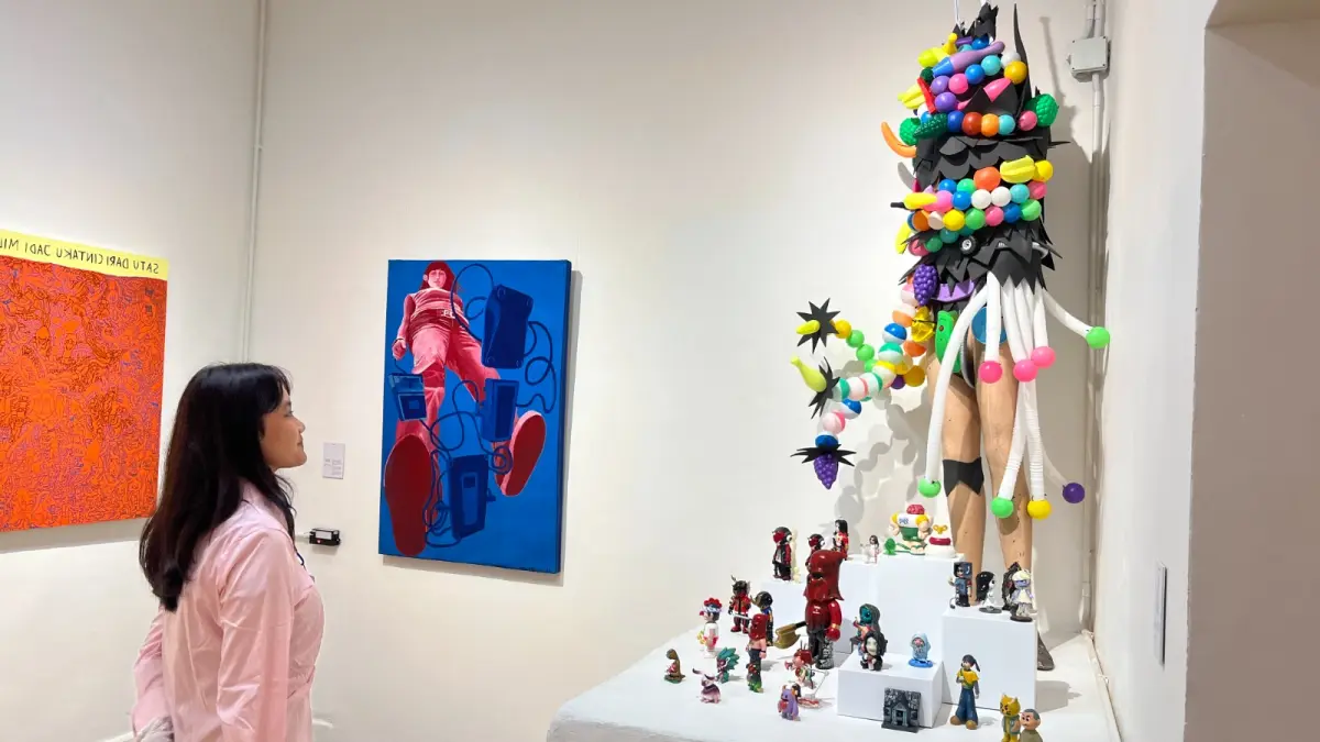 MENIKMATI SENI: Salah satu pengunjung menikmati pembukaan pameran Mukadimah di Galeri Seni Artmeru, Jalan Semeru, Kecamatan Klojen, kemarin (25/6).