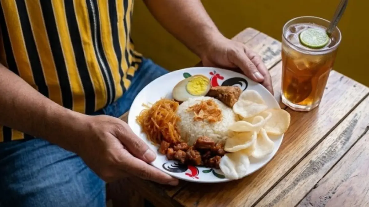 Seporsi nasi uduk dengan lauk tempe orek, bihun, telur, dan kerupuk (Instagram @wrg.sobatlestari)