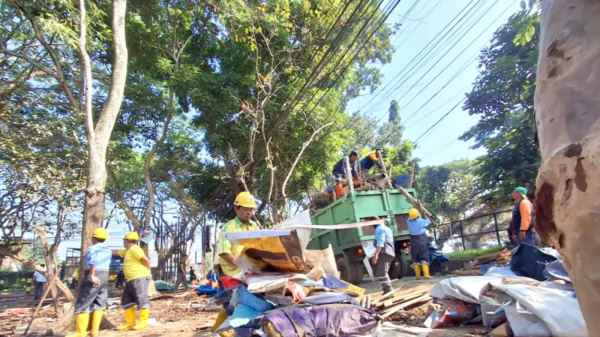 SUDAH DIBERI SP3: Petugas gabungan dari DLH dan Satpol PP Kota Malang membersihkan bangunan semi-permanen di RTH Kedungkandang, kemarin (26/6). (Nabila Amelia/Radar Malang)