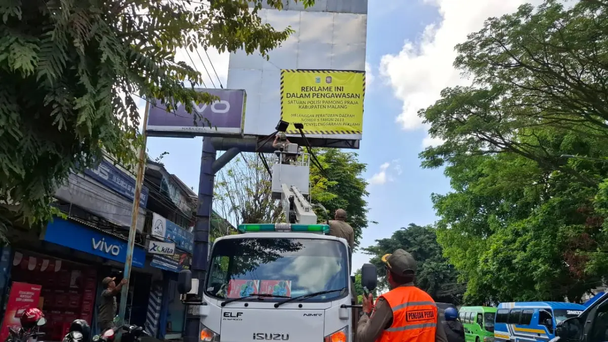 Personel Satpol PP Kabupaten Malang menertibkan reklame bermasalah di kawasan Pasar Kepanjen beberapa waktu lalu. (Dokumen Satpol PP Kabupaten Malang)