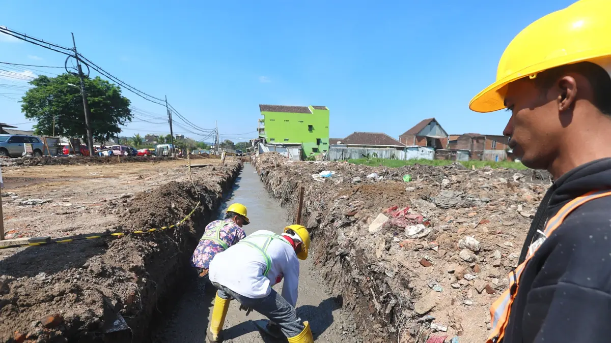 DIKEBUT: Pengecoran drainase untuk proyek jalan di Pasar Gadang dilakukan, kemarin. Tahap pengerjaan itu ditarget selesai dalam sebulan. (Darmono/Radar Malang)