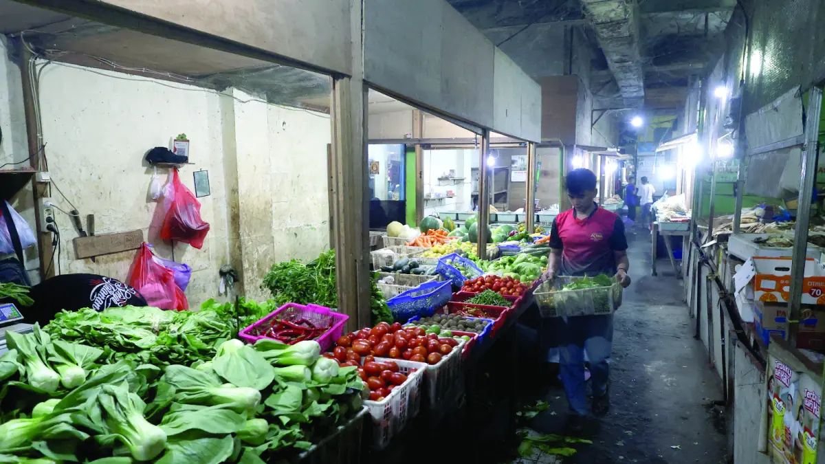 HARGA TURUN: Salah satu pedagang di Pasar Besar tengah menata sayur kemarin. Harga beberapa komoditas sayur mengalami penurunan. (Foto: Darmono/Radar Malang)