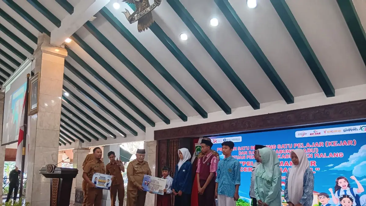 LITERASI KEUANGAN: Bupati Malang H M. Sanusi membagikan buku rekening tabungan ke perwakilan pelajar di Pendapa Agung Kabupaten Malang.