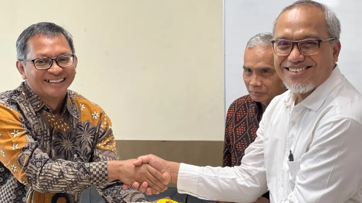 SEREMONIAL: Dekan Vokasi UB Kholid Mawardi (kiri) memberikan potongan tumpeng Prof Dr Unti Ludigdo SE MSi Ak. Fotoo. M Rizal/Radar Malang
