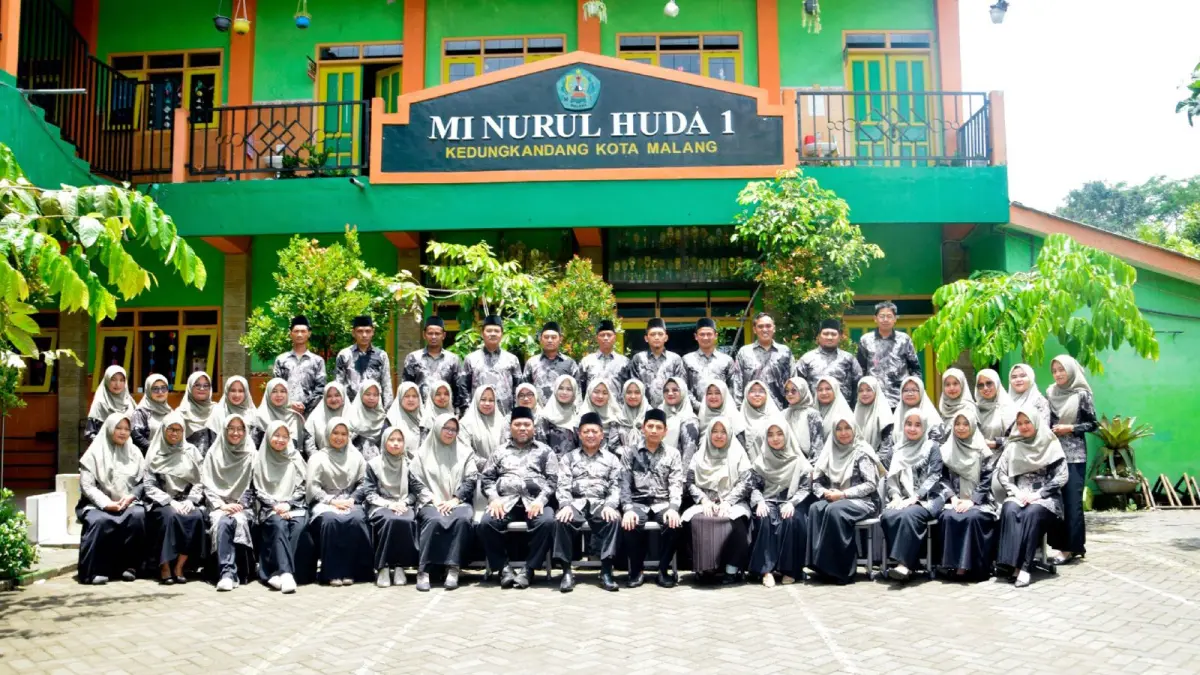SINERGIS: Para guru dan pimpinan yayasan yang menaungi MI Nurul Huda 1 Kota Malang berpose di halaman sekolah.